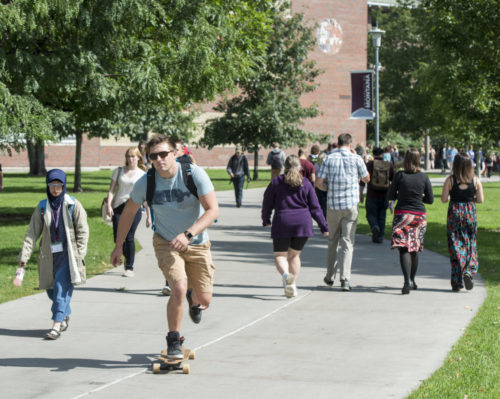 Male student on longboard, University of Montana